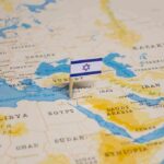 Israeli flag pinned on Middle East map.