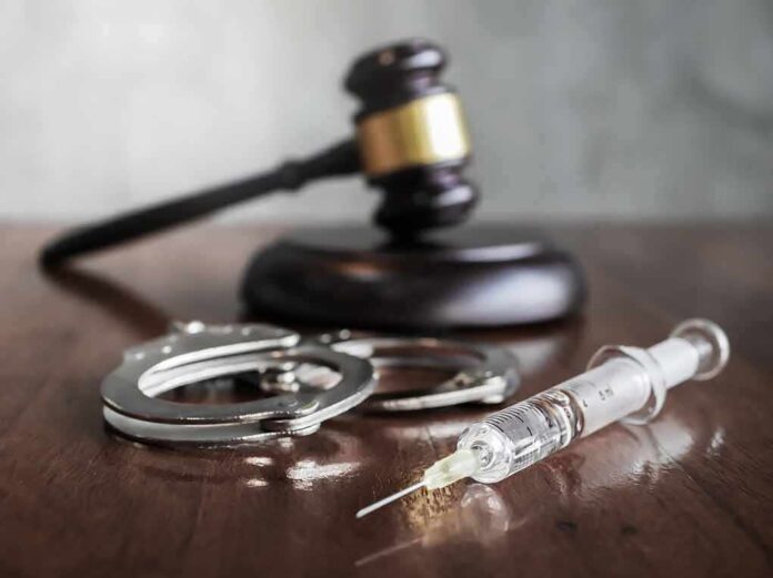 1120412354 featured image Gavel handcuffs and syringe on wooden table