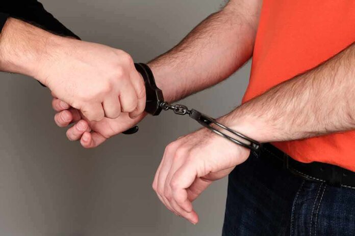 168258167 featured image Person being handcuffed wearing orange shirt jeans