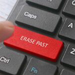 Finger pressing erase past key on keyboard.