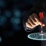 Hand aiming dart at digital target