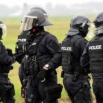 Police officers in tactical gear standing together outdoors