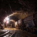 Dimly lit mine shaft with rail carts and tracks