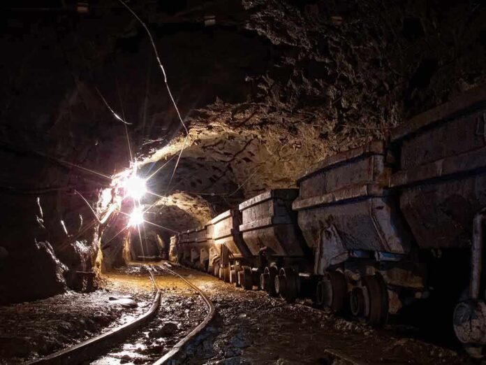 537303439 featured image Dimly lit mine shaft with rail carts and tracks