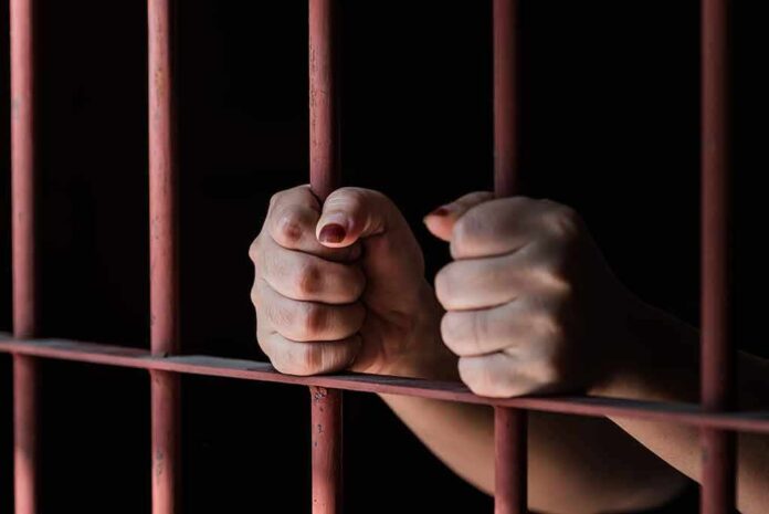 592930874 featured image Hands gripping prison cell bars tightly
