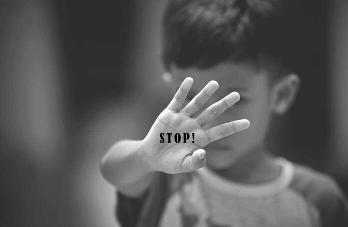 754809316 featured image Child holding up hand with stop on his palm