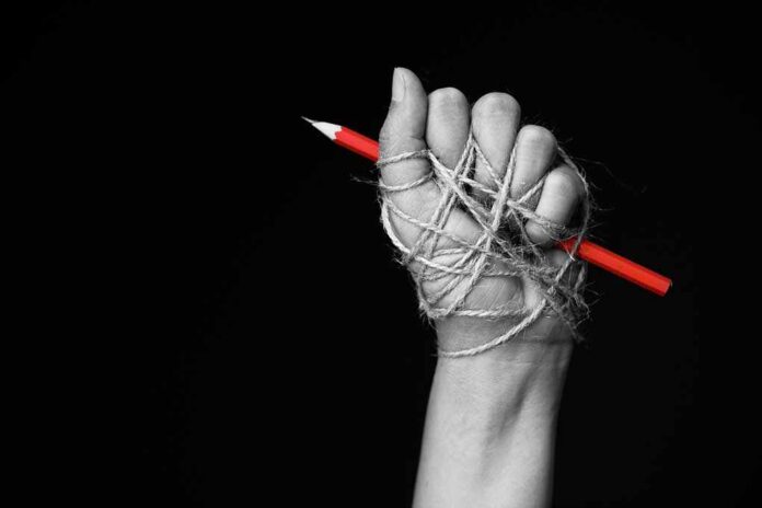 768699079 featured image Hand tied with string holding red pencil