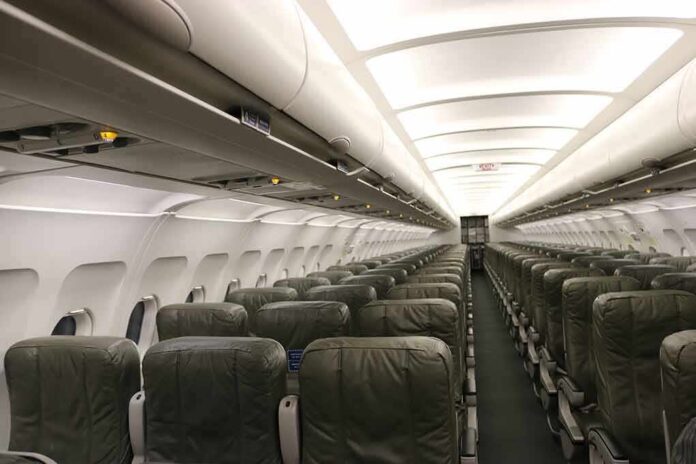 Empty airplane cabin with rows of green seats