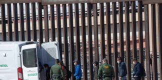 People at border with patrol vehicle and officers