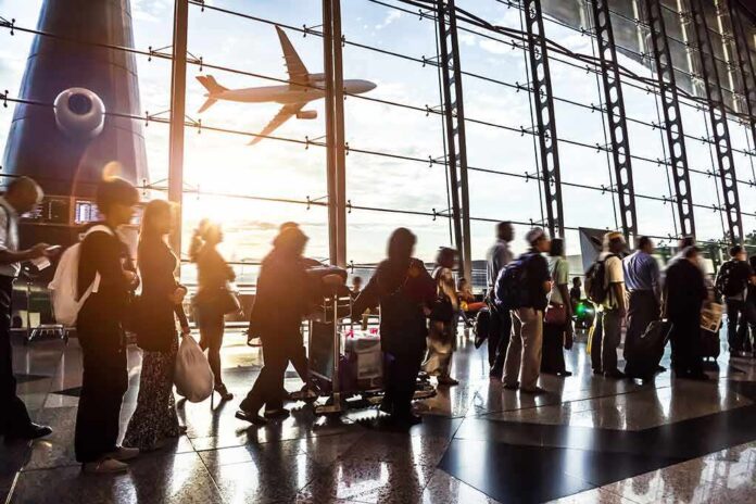 210042967 featured image Crowd of travelers in airport terminal with airplane outside