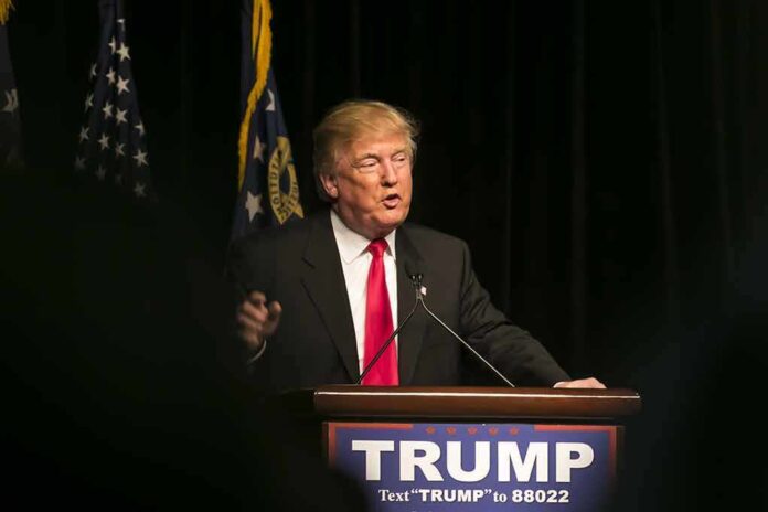 403318090 featured image Man speaking at podium with TRUMP sign