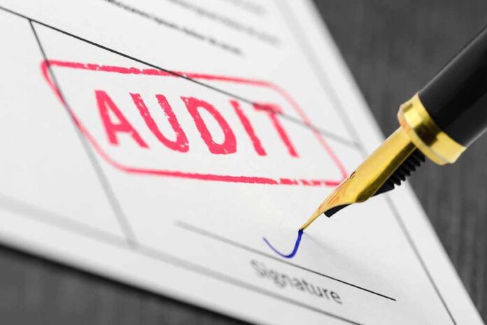 Audit stamp and pen signing a document