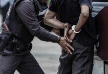 Police officer arresting a person with handcuffs
