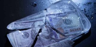 Hundred-dollar bills frozen in cracked ice block