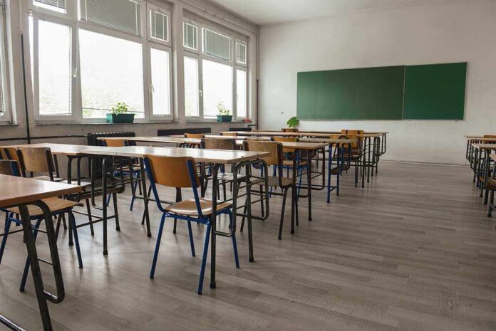 487861393 featured image Empty classroom with desks chairs windows and chalkboard