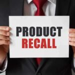 Product Recall sign held by person in suit