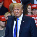 Person at a rally with Make America Great Again signs