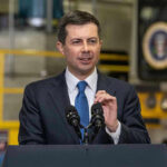 Man in suit speaking at a podium indoors