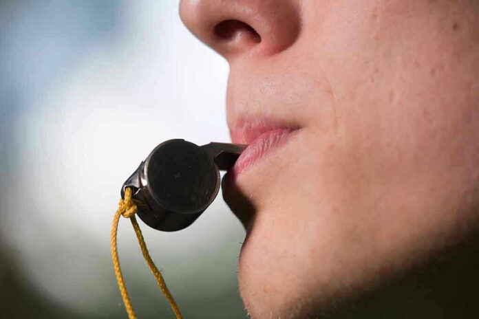 Person holding a whistle in their mouth