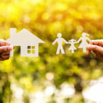 Paper cutouts of a house and family outdoors