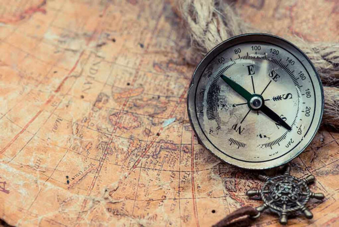 Old compass on a vintage map background