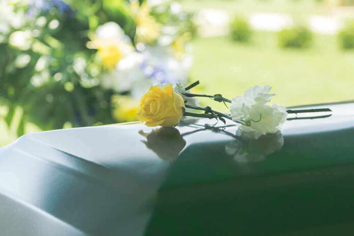 Flowers on a closed casket at a funeral.