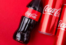 Coca-Cola bottles and cans on red background