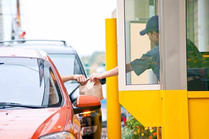 Customer receiving a food order at a drive thru window