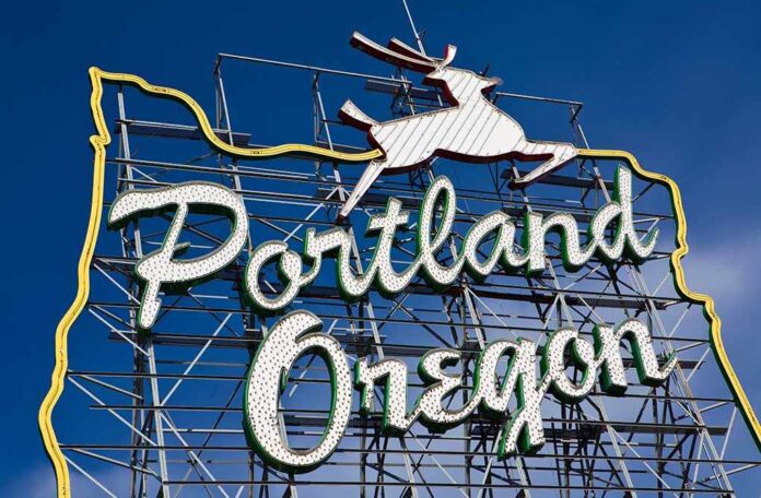 Neon sign reading Portland Oregon with a leaping deer against a blue sky