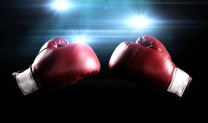Two red boxing gloves facing each other with dramatic lighting