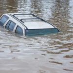 Typhoon DESTROYS Town — Homes Floating Away A partially submerged vehicle in floodwaters
