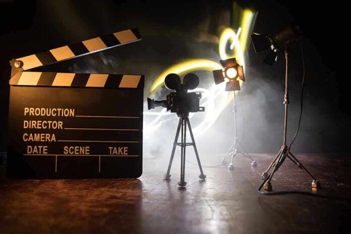 Film set with clapperboard, camera, and lighting.