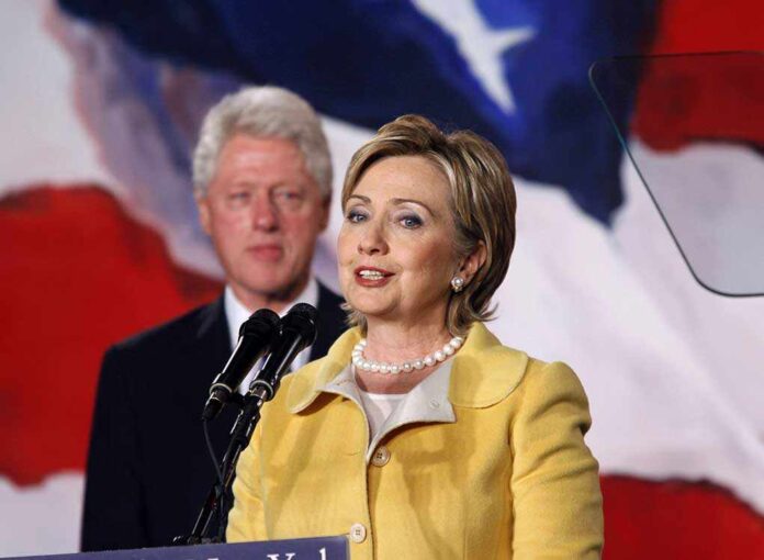 Hillary Clinton delivering a speech with Bill Clinton in the background