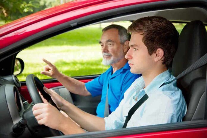 A young man driving a car with an older man giving instructions