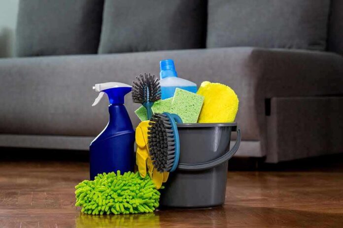A bucket filled with various cleaning supplies including sponges, brushes, and spray bottles