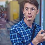 Young man using a smartphone with face recognition overlay