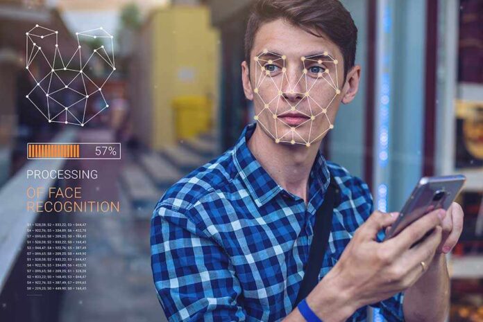 Young man using a smartphone with face recognition overlay
