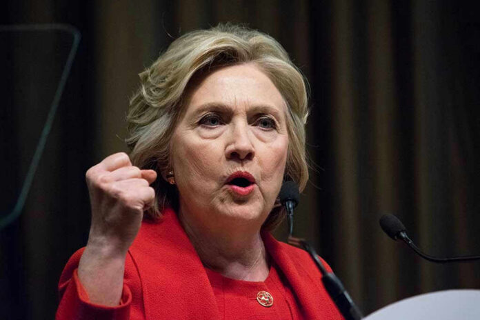 Person speaking passionately at a podium, wearing red jacket.