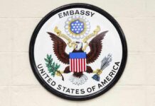 Seal of the United States Embassy featuring an eagle and the American flag