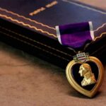 Purple Heart medal with a portrait of George Washington next to a vintage book