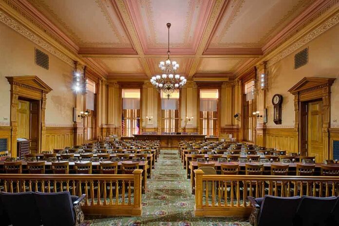 Interior view of a historic courtroom with wooden furnishings and chandeliers