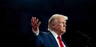 A man in a suit gesturing during a speech