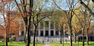 Secret Land Grab for Trump Library?! Students walking on a university campus with autumn trees and a historic building in the background