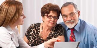 A financial advisor discussing documents with an elderly couple
