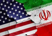 Iran’s Shadow Play Exposed At World Cup Cracked American and Iranian flags painted on a wall.