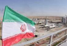 Iranian flag near an industrial gas refinery.