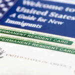 Permanent resident cards with welcome guide and flag.
