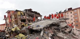 18-Day-Old Baby Was Still Alive Rescue workers in orange uniforms on a collapsed building site after an earthquake