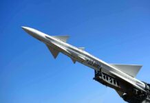 A military missile pointed upwards against a clear blue sky