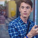 UK Digital ID Backlash Explodes Young man using a smartphone with face recognition overlay